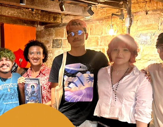 Grupo de artistas de quadrinhos em frente de uma livraria