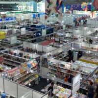 Interior do Hangar Centro de Convenções em Belém com artes promocionais da feira literária.