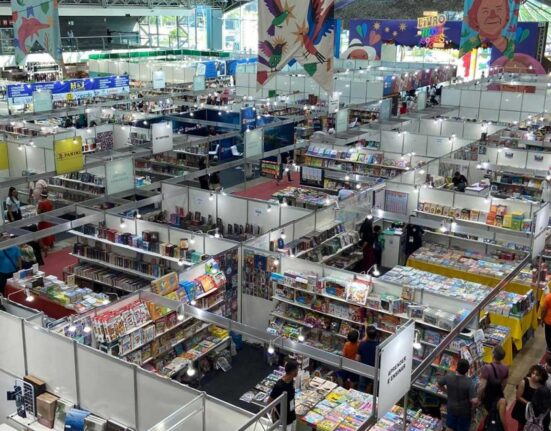Interior do Hangar Centro de Convenções em Belém com artes promocionais da feira literária.