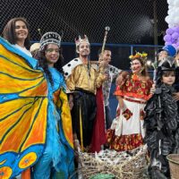 Grupo de teatro popular Pássaro Urubu com fantasias coloridas e maracas, prontos para apresentação em Belém.