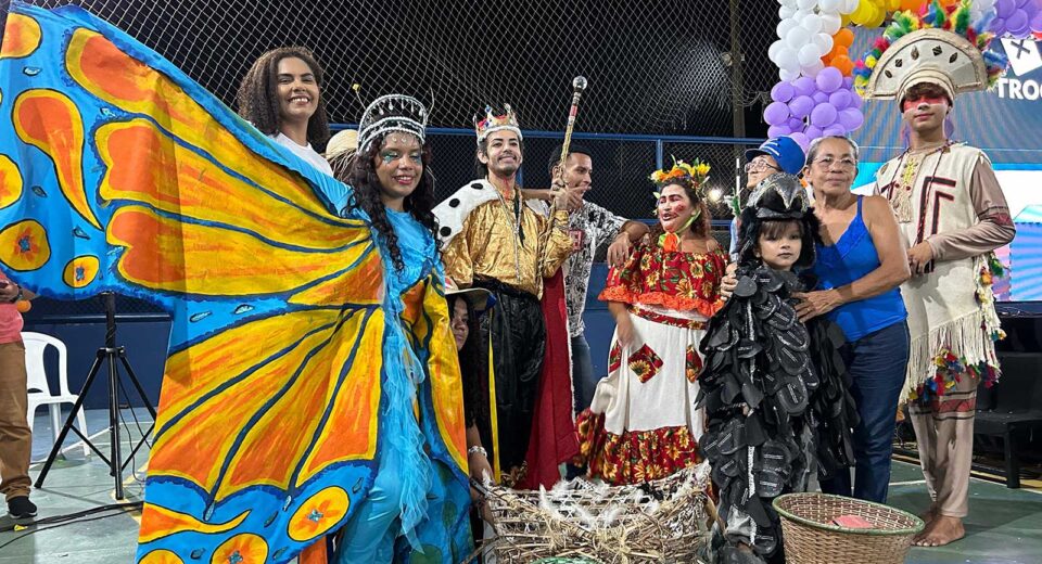 Grupo de teatro popular Pássaro Urubu com fantasias coloridas e maracas, prontos para apresentação em Belém.